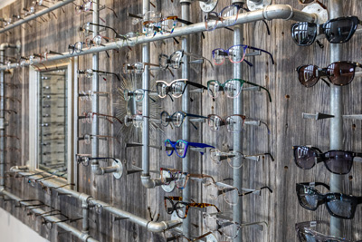 Eyeglasses display on a rustic wall rack.