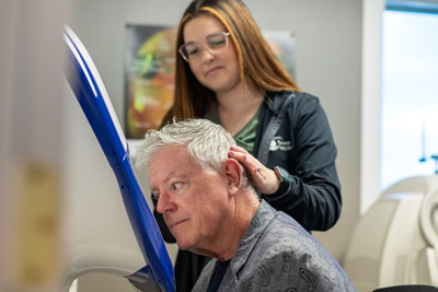 Technician assisting a patient during an eye exam.