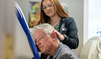 Technician assisting a patient during an eye exam.