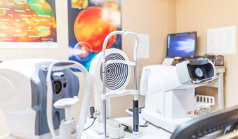 Optometry exam room with diagnostic equipment.