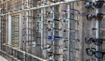 Eyeglasses display on a rustic wall rack.